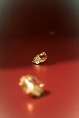 Aros de estilo orgánico, con forma irregular y textura martillada, en tono dorado.