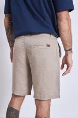 Bermuda color beige confeccionada en lino, con bolsillos laterales y traseros.