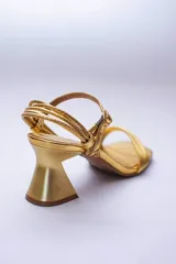 Sandalias de tiras finas color lila metalizado, con taco geométrico plateado.