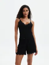 Short de pijama color lila con estampado de flores blancas y ribete de encaje en el ruedo.