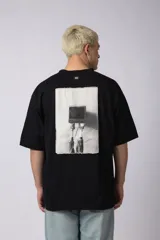 Remera color crema de corte oversize con la inscripción '90's' bordada en el frente y parche con imagen en la espalda.