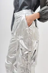 Pantalón plateado metalizado de corte holgado con bolsillos laterales y lazo en la cintura.