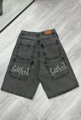 Bermuda de jean gris oscuro con bolsillos traseros y laterales. Estampado de llamas blancas en los bolsillos delanteros.