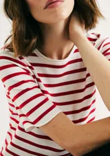 Camiseta de tejido de punto blanca con rayas horizontales rojas, cuello redondo y mangas cortas.