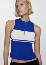 Top azul con panel blanco horizontal, de tejido de punto fino en canalé, cuello perkins y cierre de cremallera en el cuello.