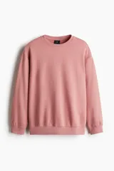 Buzo rosa de tejido liviano de mezcla de algodón con interior cepillado suave, cuello redondo ribeteado, hombros caídos y remate ancho acanalado en puños y bajo. Corte holgado.
