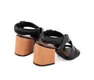 Sandalias negras de cuero con tiras cruzadas y talón elástico fruncido. Taco de madera de 7,5 cm y punta cuadrada.