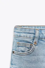 Pantalón de jean azul oscuro, de tiro alto, corte wide leg y largo al tobillo.