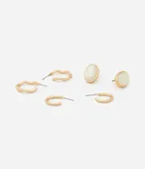 Set de tres pares de aros dorados con diferentes diseños: un par de aros tipo botón ovalados con centro blanco, y dos pares de aros tipo argolla. Fabricados con metal reciclado.