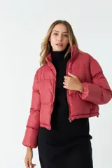 Campera corta de nylon color rojo con cuello alto, cierre completo y bolsillos.