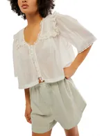 Blusa blanca de algodón con escote en V, mangas cortas y detalle de bordado tipo encaje.