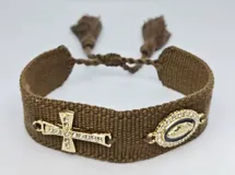 Pulsera tejida color gris con cierre ajustable y dijes dorados: una cruz con strass y un dije ovalado con la imagen de la Virgen María rodeada de strass.