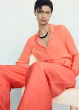 Pantalón largo color naranja, de tejido mezcla de lino y lyocell, con diseño wide leg, trabillas, dos bolsillos laterales y dos bolsillos de ribete en la parte posterior.