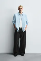 Pantalón de jeans de algodón, corte baggy fit, tiro medio, con efecto lavado en tonos grises y verdes. Presenta cinco bolsillos y cierre frontal con cremallera y botón.