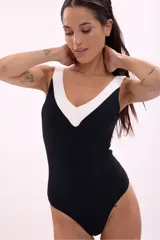 Traje de baño enterizo negro con escote en V y ribete blanco.
