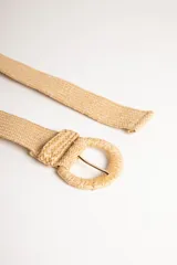 Cinturón ancho color beige, de rafia trenzada, con hebilla redonda metálica.