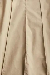 Pollera midi color beige con tiro alto, diseño circular y rayas cosidas. Presenta cierre oculto y corchete en un lateral. Sin forrar.