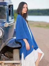 Ruana azul de tejido de punto calado, con mangas 3/4 y largo irregular.