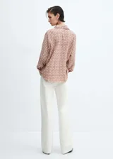 Camisa de manga larga con cuello camisero y cierre de botones frontal. Estampado geométrico en tonos terracota y blanco.