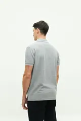 Remera polo verde militar con textura, corte regular, cuello clásico con detalles en azul marino y logo estampado en el pecho.