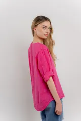 Blusa celeste de lino, con escote en V, manga tres cuartos y botón de madera.