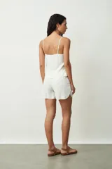 Short negro de tiro alto con cordón ajustable en la cintura y bolsillos laterales. Presenta un corte holgado y ruedos redondeados.