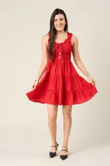 Vestido corto rojo con escote fruncido, tirantes anchos con volantes y cuerpo de nido de abeja. Falda con diseño escalonado.