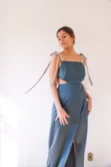 Vestido largo amarillo pálido con escote recto, breteles finos con lazos blancos y falda cruzada con abertura lateral.