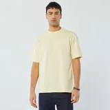 Remera color amarillo claro, de corte recto y mangas cortas.