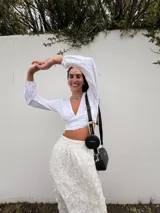 Bandolera pequeña de símil cuero color negro, con correa ancha regulable y un monedero circular desmontable adherido a la correa.