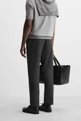 Pantalón chino negro slim fit confeccionado en tejido técnico de secado rápido. Cuenta con bolsillos frontales y traseros de vivo. Cierre frontal con cremallera y botón.