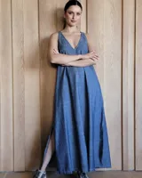 Vestido largo azul melange de corte imperio, con escote en V y breteles finos. Presenta una abertura lateral en la falda.