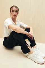 Pantalón negro de punto, corte suelto, con elástico en la cintura y aberturas en el ruedo.