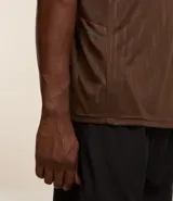 Remera deportiva gris con cuello redondo, mangas cortas, estampa heat print y detalle en los hombros. Confeccionada en tejido de malla con tecnología Dry.