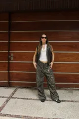 Chaleco marrón de cuero sintético con cuello solapa, cierre frontal asimétrico con cremallera, bolsillos con cremallera y corte ajustado.