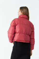 Campera puffer corta color ladrillo, con cuello alto y cierre frontal.