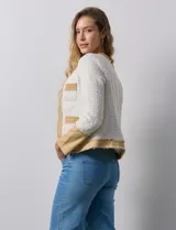 Chaqueta Nanette en tejido tweed color crudo con detalles en denim azul. Tiene cuello a la base, abertura central, bolsillos delanteros, puños con aplique de botones perlados, terminación desflecada y forro interno.