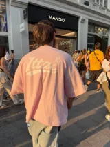 Remera negra de corte holgado con estampado en la espalda con la palabra "Ittai" en blanco y una estrella.