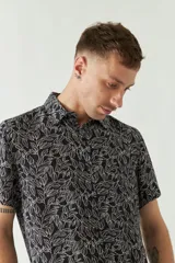 Camisa de hombre estampada, de manga corta y fit slim. Presenta cartera abotonada y logo bordado.