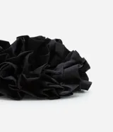 Accesorio para el pelo tipo scrunchie negro con volantes.