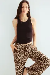 Pantalón de viscosa con estampado de leopardo, tiro alto, cintura elastizada con cordón ajustable, bolsillos laterales y corte amplio.