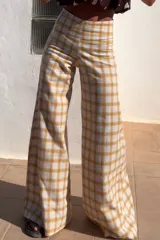 Pantalón de lino italiano con estampado escocés en tonos marrón, beige, amarillo y naranja. De tiro medio alto y corte oxford.
