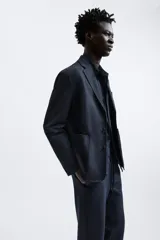 Pantalón negro de corte cropped, con cintura elástica ajustable con cordón, bolsillos laterales y traseros de vivo. El bajo tiene terminación con vuelta.
