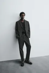Pantalón de vestir de corte slim fit, color gris oscuro con micro estampado a cuadros. Cuenta con bolsillos laterales y traseros de doble vivo con botón. Cierre frontal con cremallera y botón.