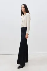 Pantalón de jean negro de tiro alto y pierna palazzo, confeccionado en denim con elastano y coating negro con apariencia similar al cuero.