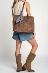 Bolso tipo tote de gamuza vegana color camel, con asas de mano y logo grabado en el frente.