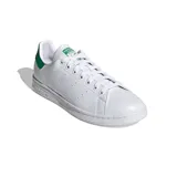 Championes Adidas Stan Smith blancos de cuero, con detalles verdes en el talón y la lengüeta. Diseño clásico con perforaciones laterales y suela de goma.