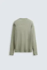 Jersey color verde claro de punto tejido en hilatura ligera de lino, corte relaxed fit, cuello redondo y manga larga con terminaciones en rib.