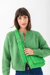 Bandolera acolchada color verde lima, con correa ancha ajustable con hebilla metálica.