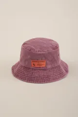 Gorro tipo bucket color lila con etiqueta naranja con el logo de la marca Benson & Thomas.